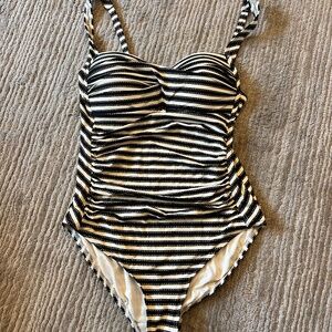 Nip Tuck one-piece swimsuit in black, cream stripes with subtle gold accents